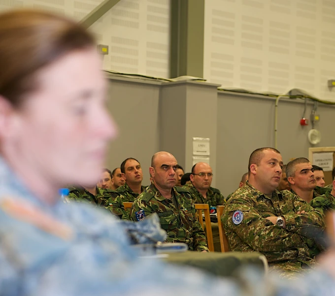 many soldiers are in their military uniform listening