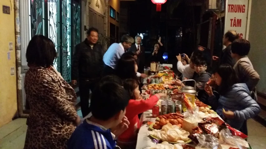 a group of people standing around a table