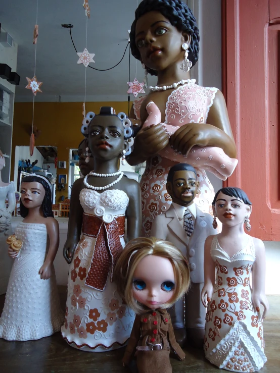 a lot of dolls in dresses on a wooden floor