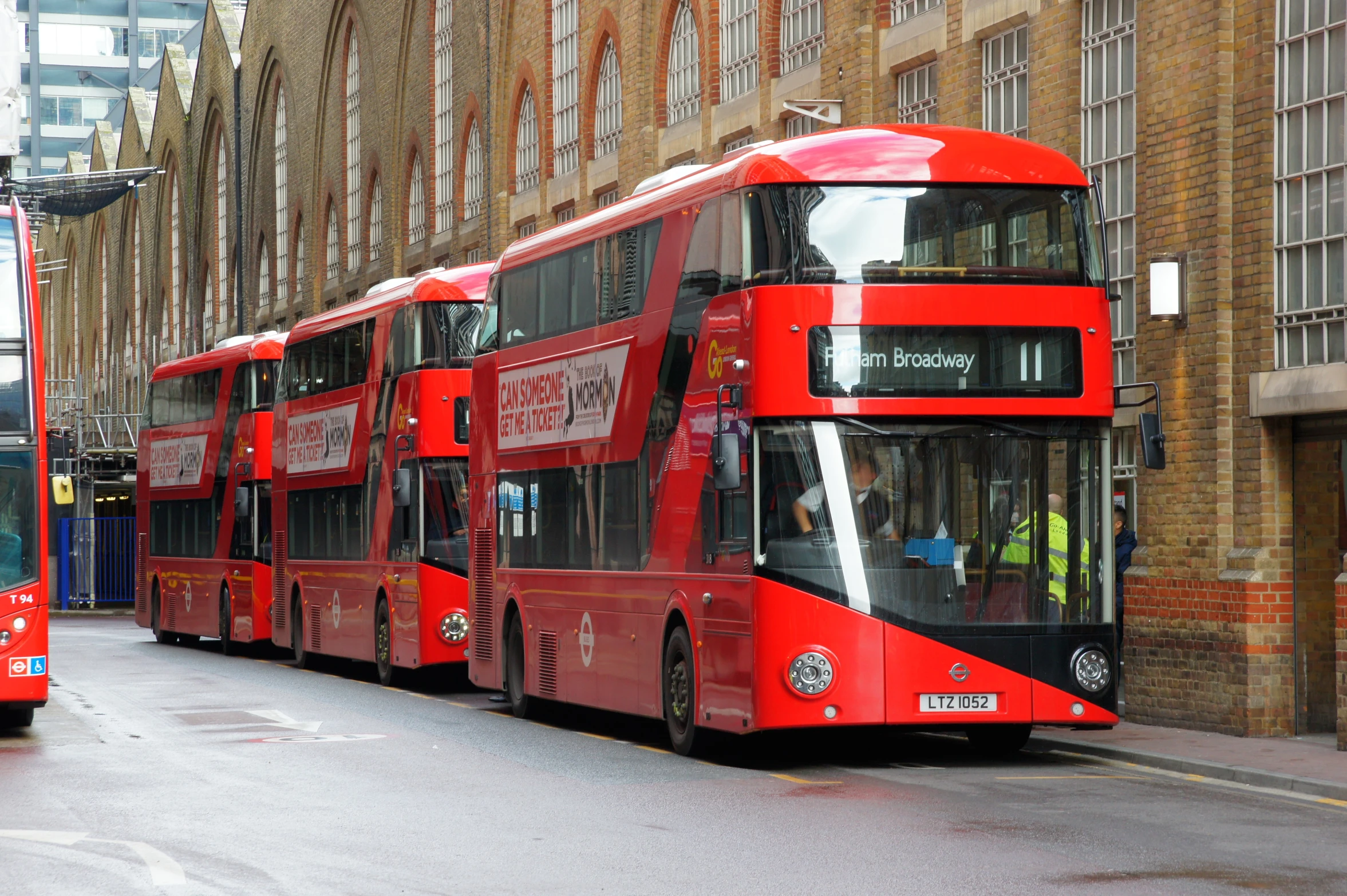 the double - decker bus is painted red in the city