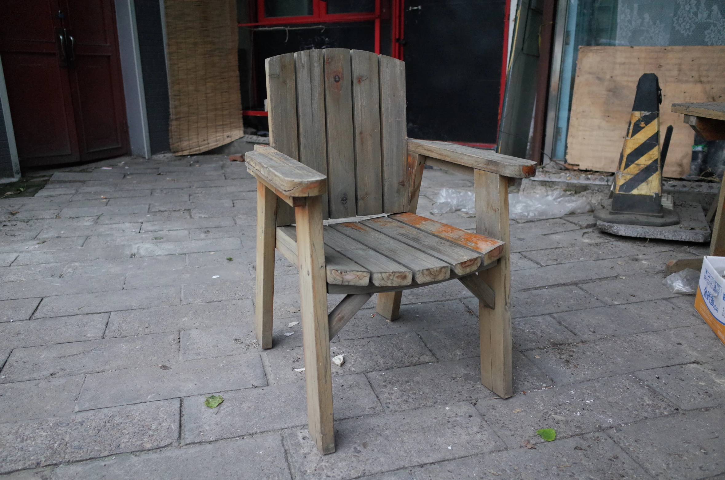 a wooden chair sitting in the middle of a walk way