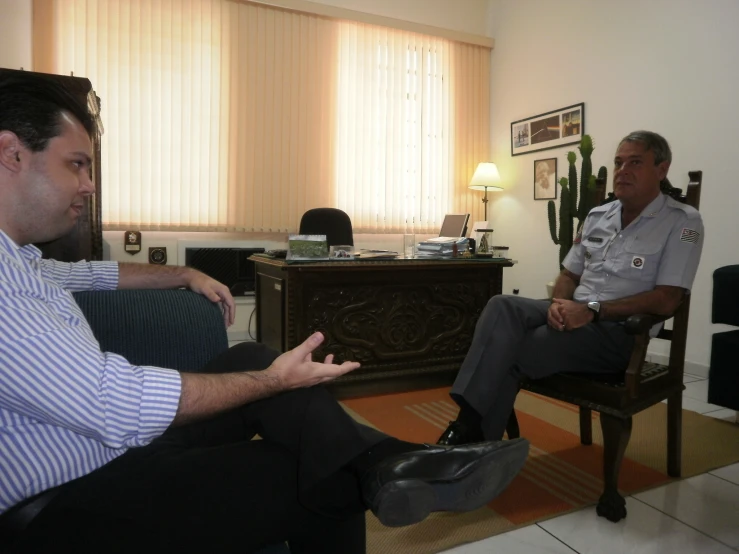 two military men are sitting in chairs talking