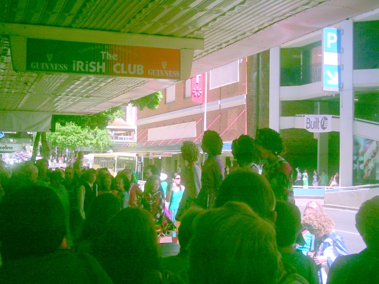 people outside of a restaurant with large signs overhead