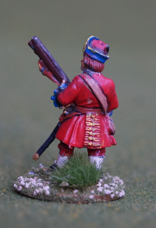 toy soldier holding rifle while holding large metal object