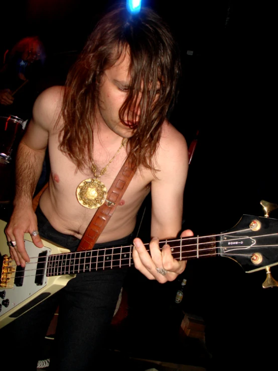 a man with long hair playing a guitar