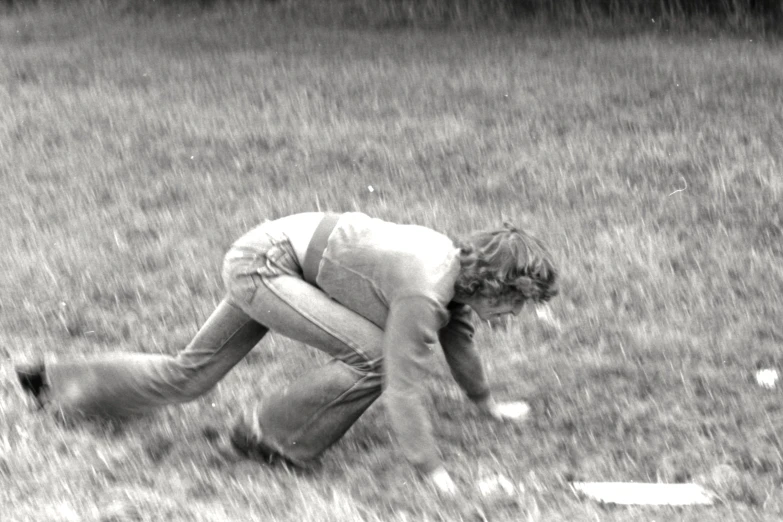 a man kneeling on the ground picking up soing