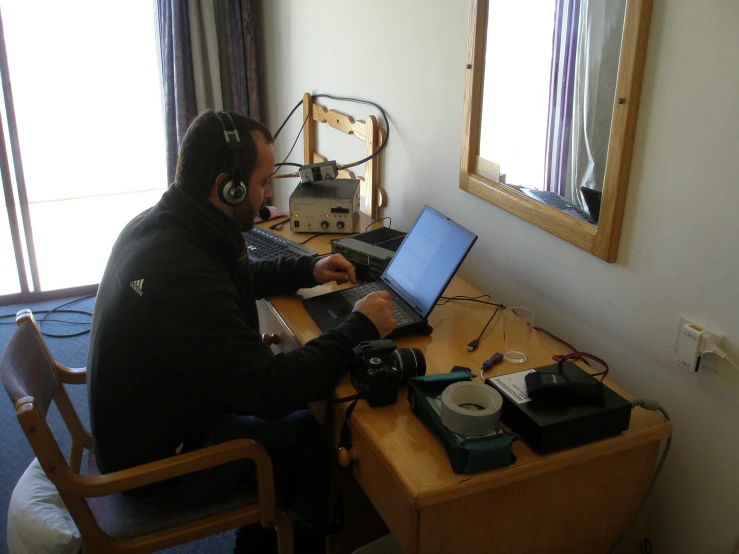 a man in headphones works on a laptop