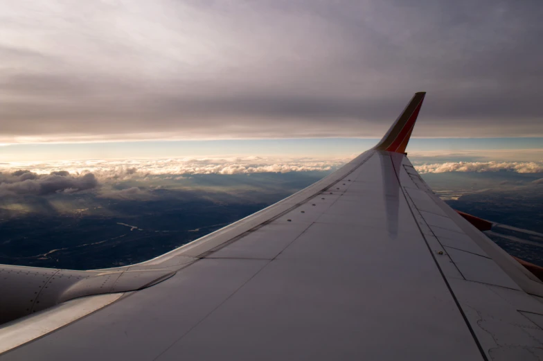 looking down from the wing of a airplane with the view out over the clouds