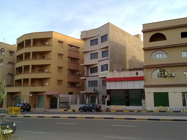 multiple brown buildings sitting beside each other with a car