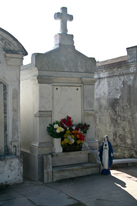 a nun sitting beside a grave on a sidewalk