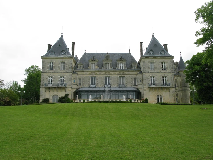 a big old, historic house in the middle of a grass area