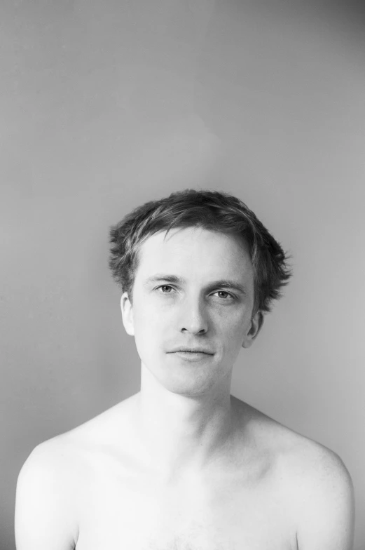 a shirtless man looking directly into the camera