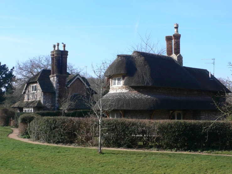 an old house in a park surrounded by hedges