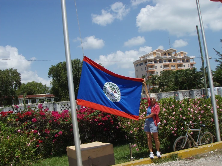 woman with a flag by some pink flowers