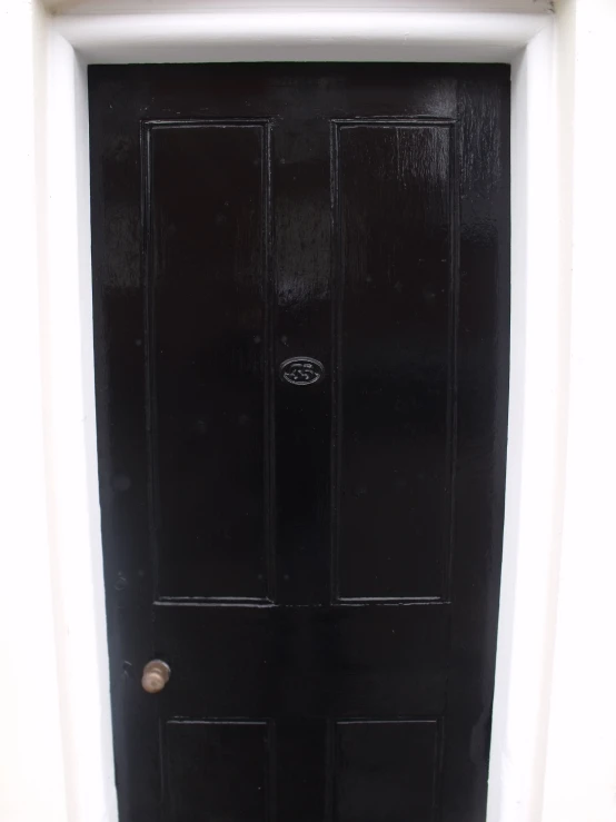 a dark colored black door and white trim