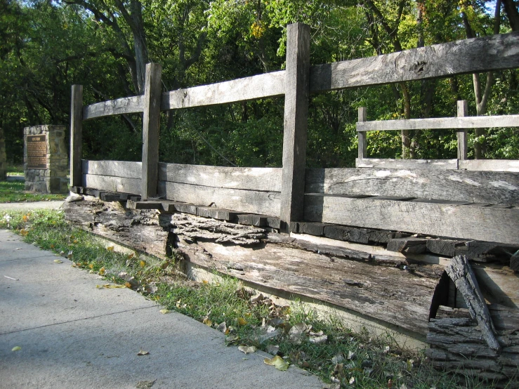 an old wooden fence sitting next to a sidewalk