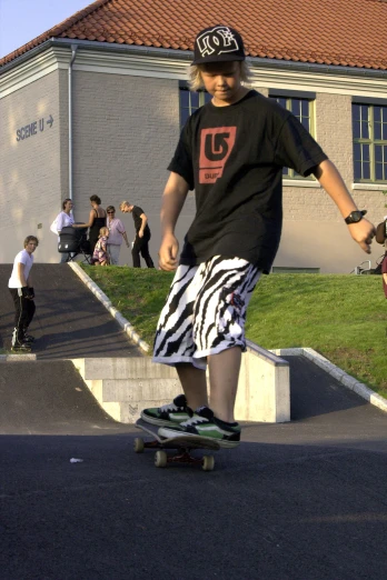 a  in shorts and t - shirt on a skateboard