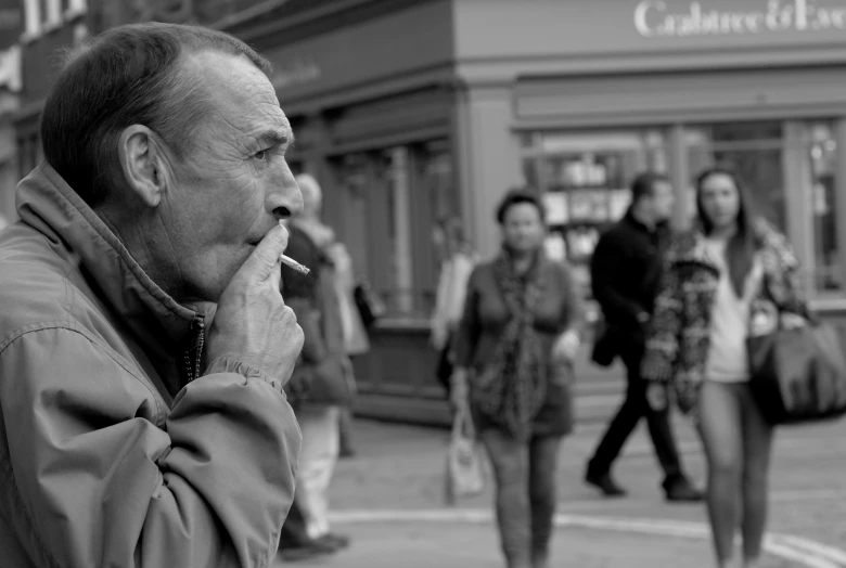 a man with his finger up to his mouth is smoking