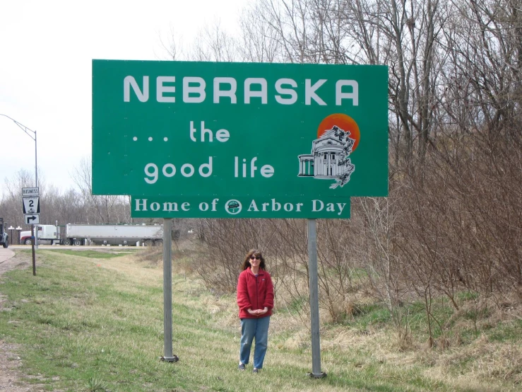 woman standing next to the road that signs are on