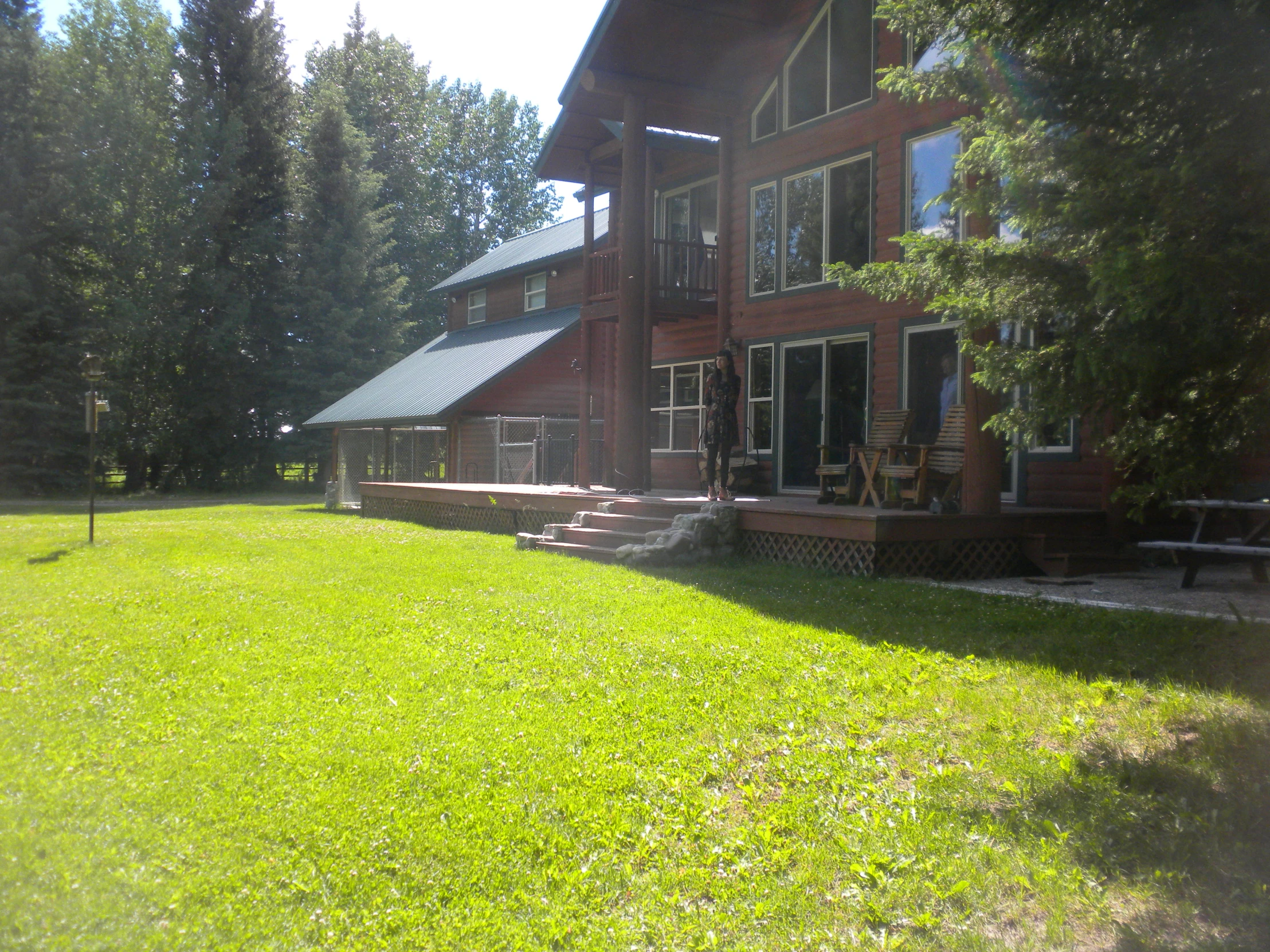 the back of a large red building with a deck and a bench