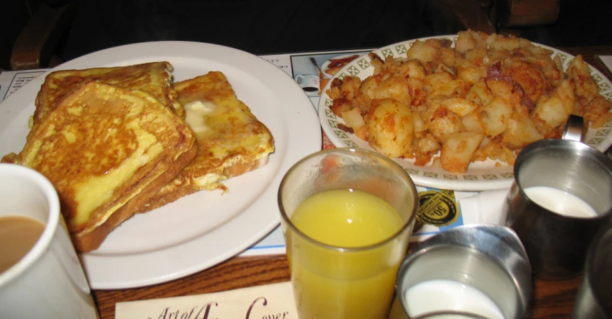 there are three plates with breakfast food next to two cups