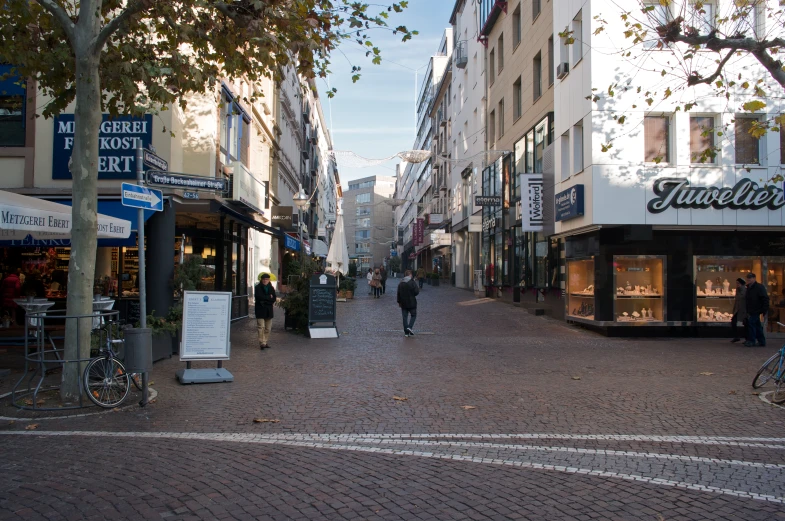 the woman is walking along the cobblestone street
