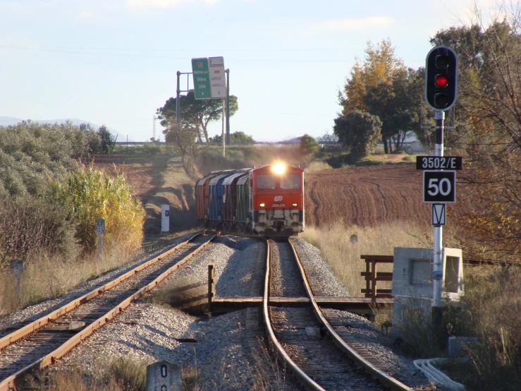 a train going down the tracks near a traffic signal