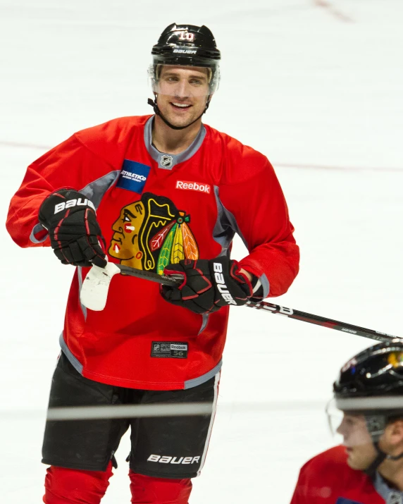 a hockey player standing next to the net with his stick