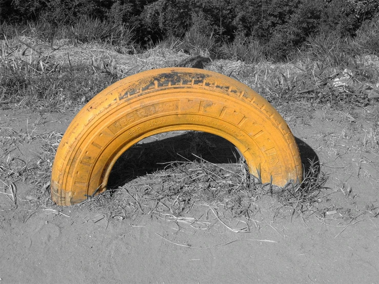 a yellow tire is lying in the grass