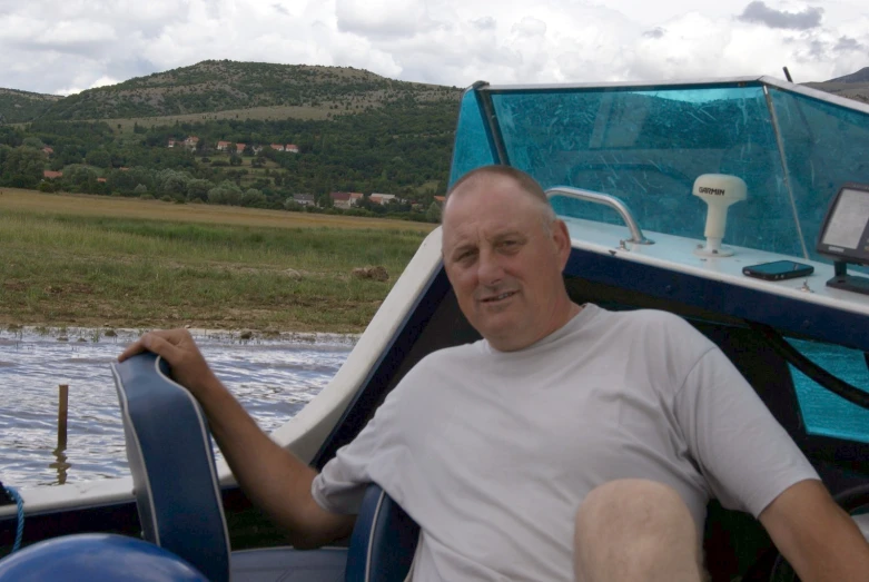 a man with white hair sitting on a boat