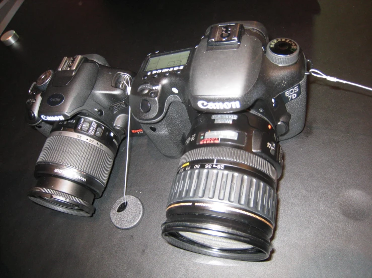 two large digital cameras on top of a table