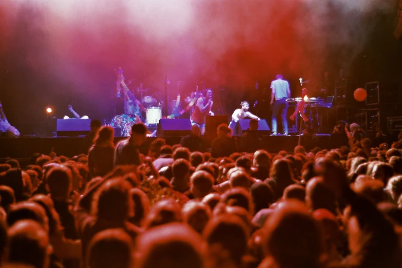 a crowd of people on stage and in front of two men on their laptops