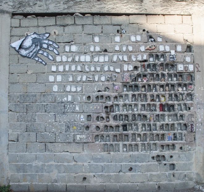 a graffiti with white and blue designs on a grey brick wall