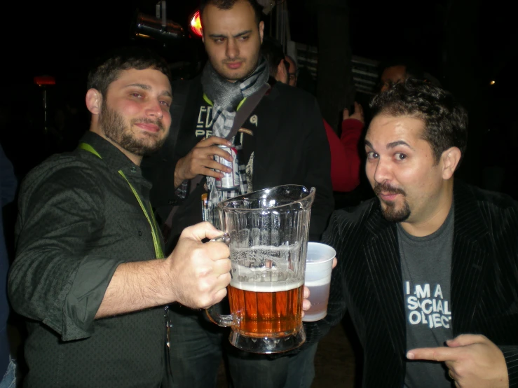 two men toasting with beer in a bar