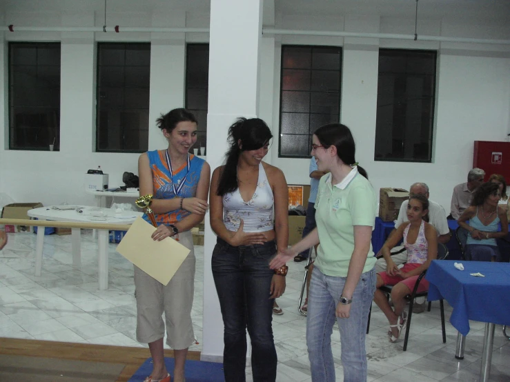 three girls in green shirts standing and laughing