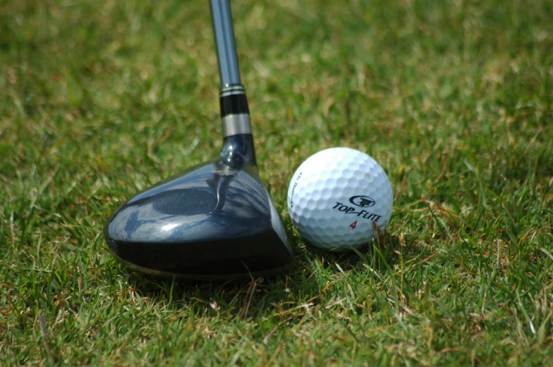 two golf ball on the tee near a driver