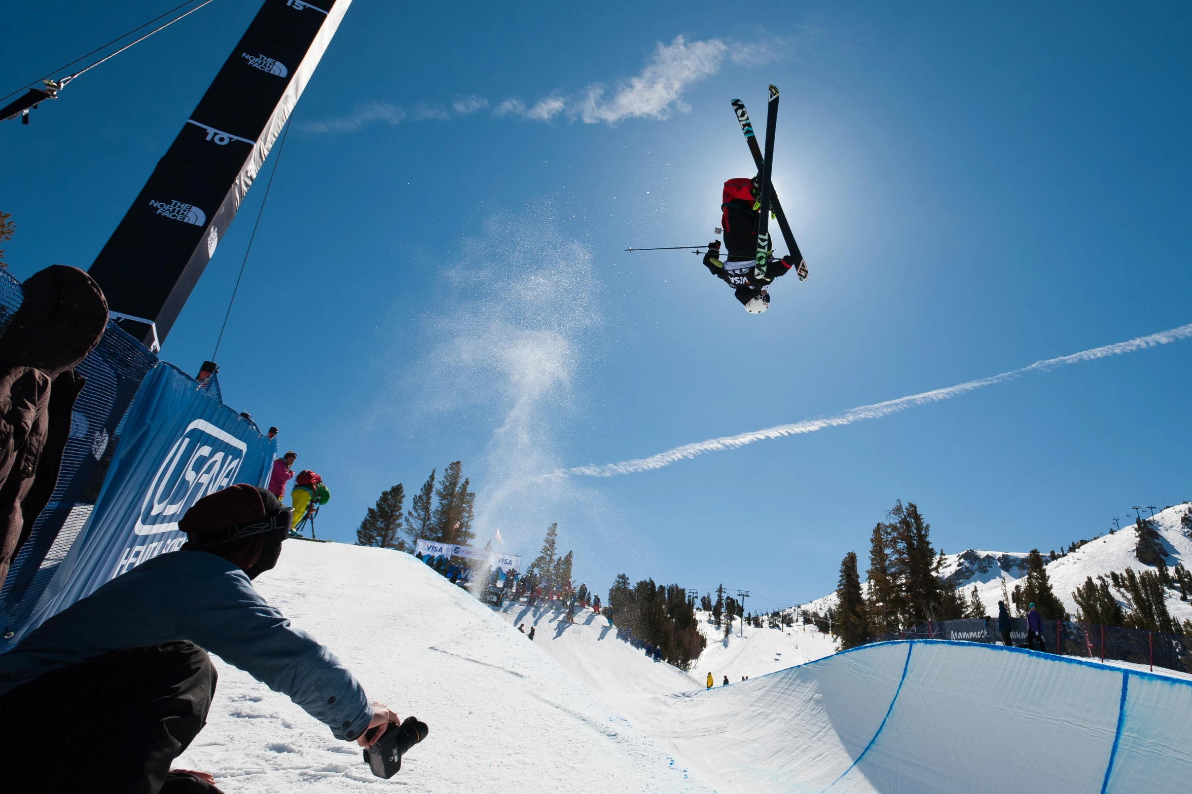 the skier is in the air as he performs his trick