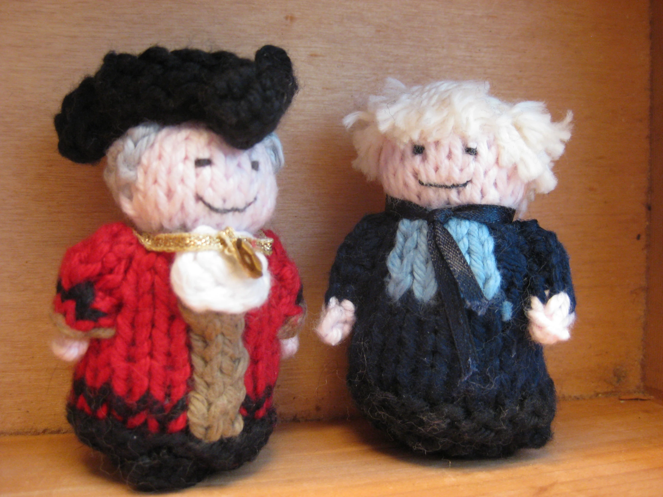 two knitted doll standing next to each other