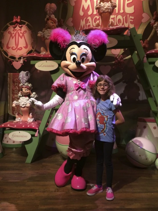 a  standing next to a minnie mouse character