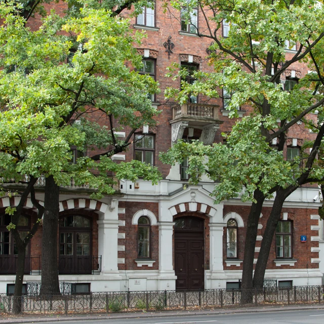 the building is next to trees on the sidewalk