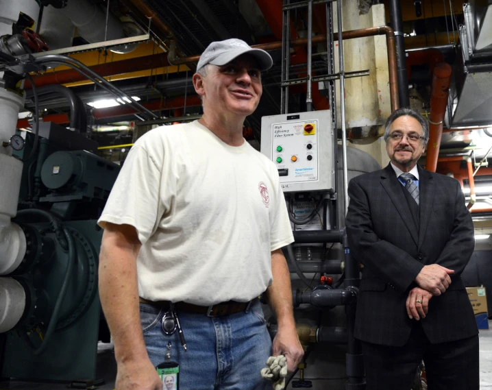 two men standing in front of a factory