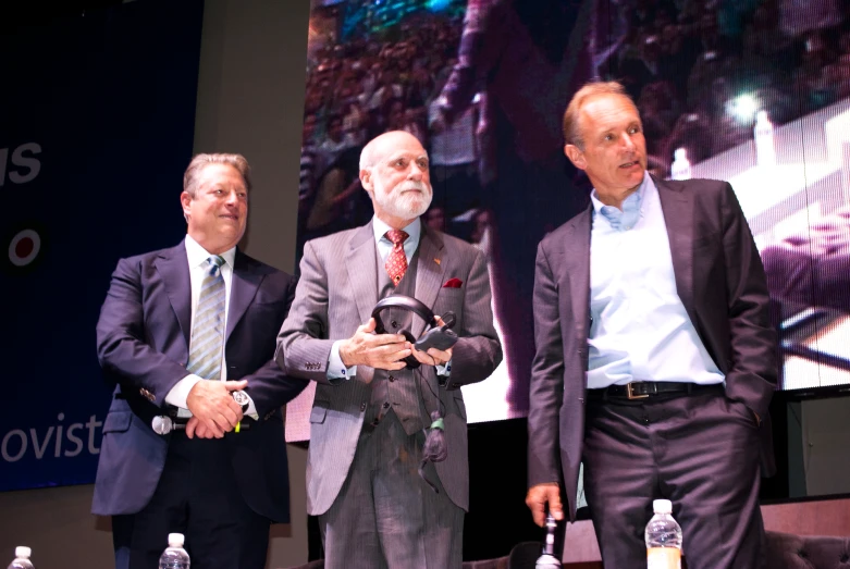 four business men standing near each other in front of a stage