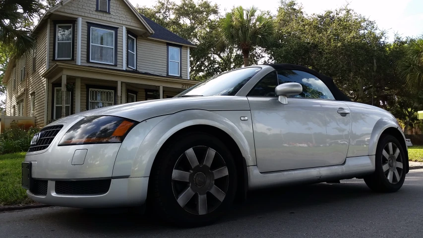 a white convertible car parked in front of a home