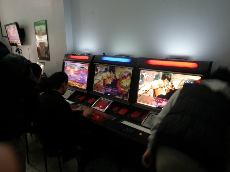 a group of people are gathered around the video game machines