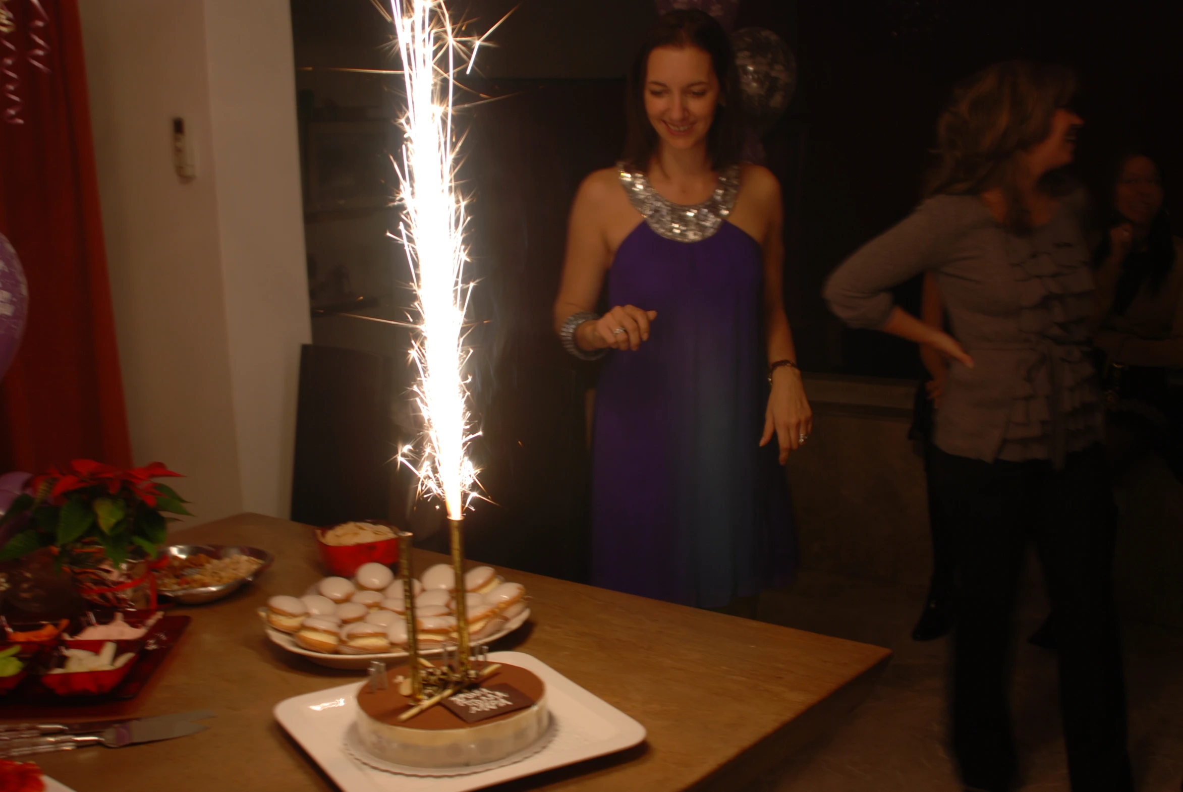 two girls standing around a table with fireworks in the middle