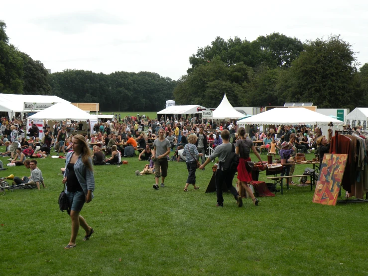 a crowd of people standing around some tents