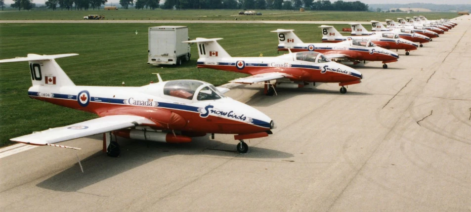 a line of airplanes parked in an airport runway