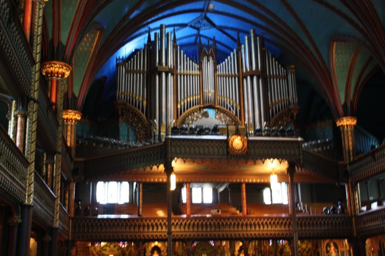 a large pipe organ above a wooden floor inside of a building