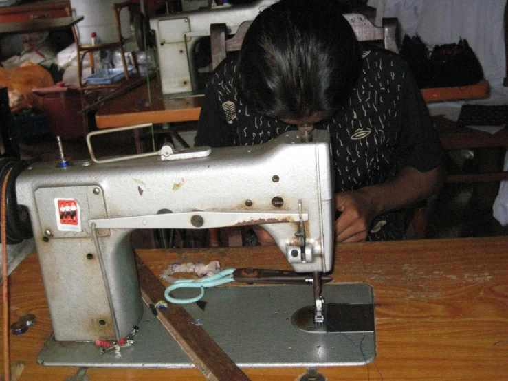 a girl sews on an old sewing machine