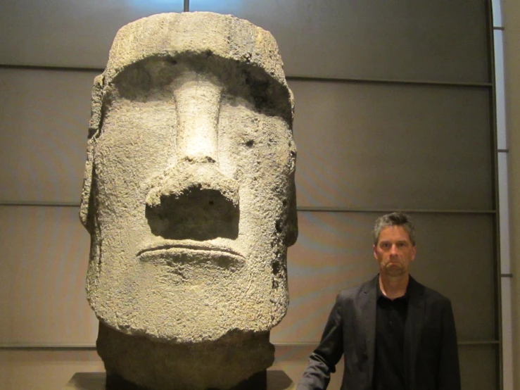 a man standing by a sculpture in a room